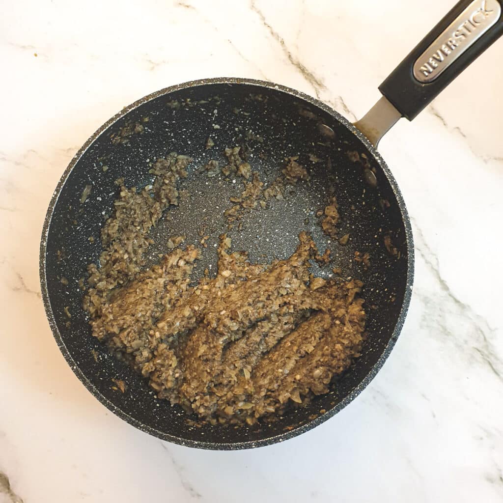 The cooked mushroom filling in a saucepan showing the texture.