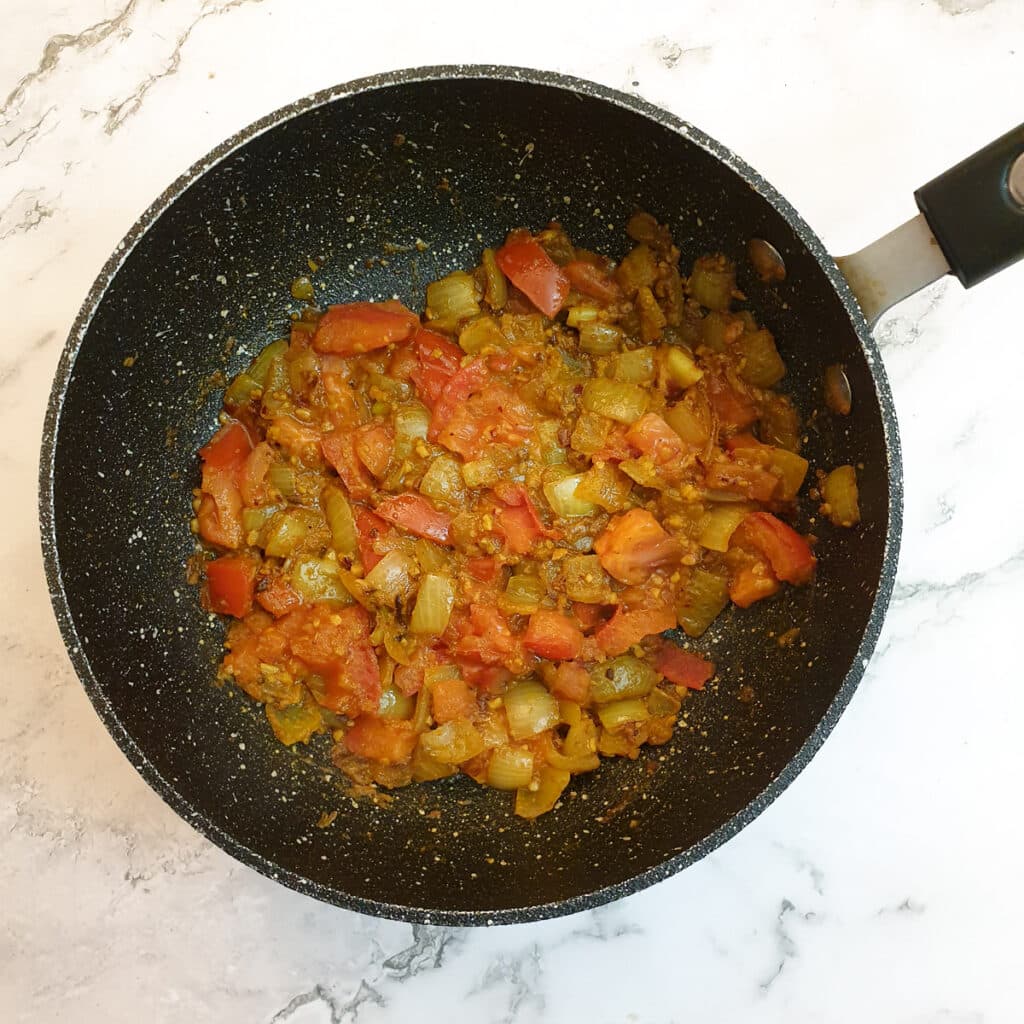 Tomatoes added to the onions and spices.