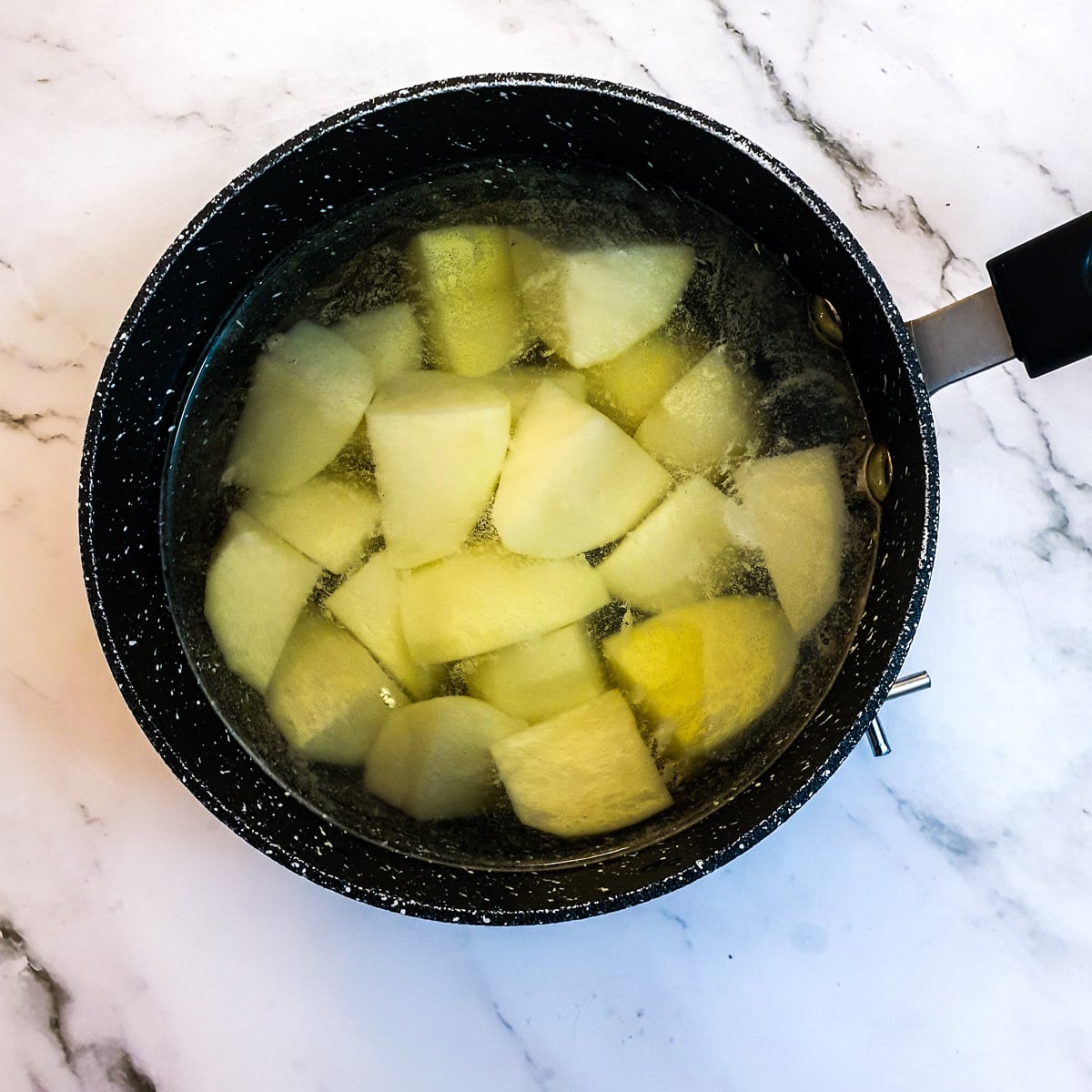 Potatoes boiling in a saucepan.