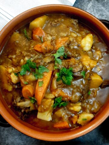 A dish of easy beef stew garnished with chopped parsley.