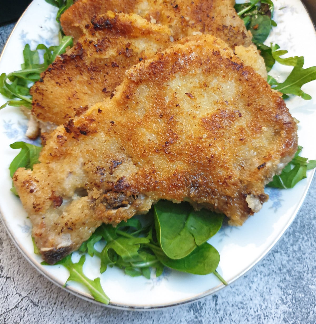 Close up of a freshly fried parmesan-crusted pork chop.