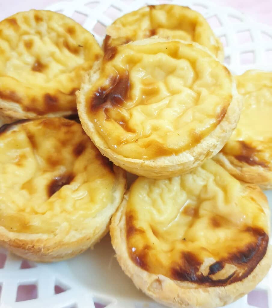 Close up of Portuguese custard tarts on a plate.