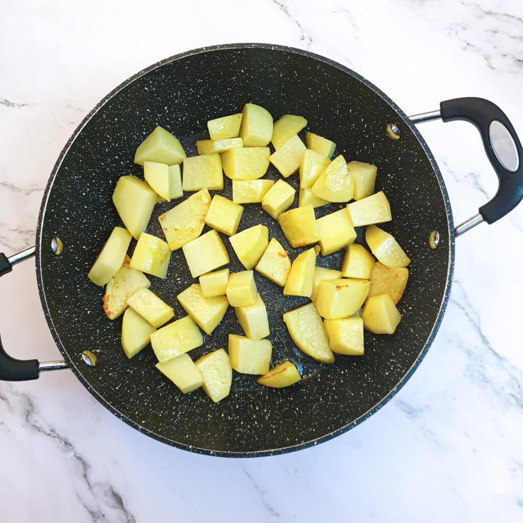 Potatoes browning in a frying pan.