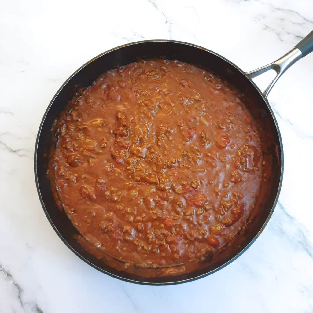 The thickened tex mex beef pie filling in a frying pan.