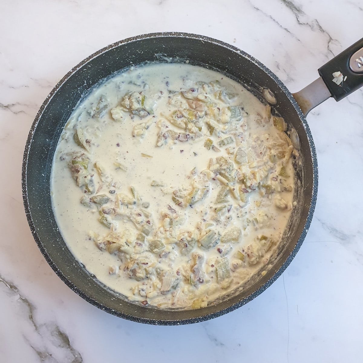 Beaten egg and cream added to the walnut and stilton filling in a saucepan.