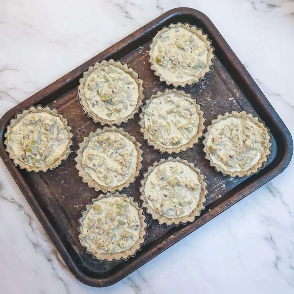 8 unbaked walnut and stilton tarts ready for the oven.