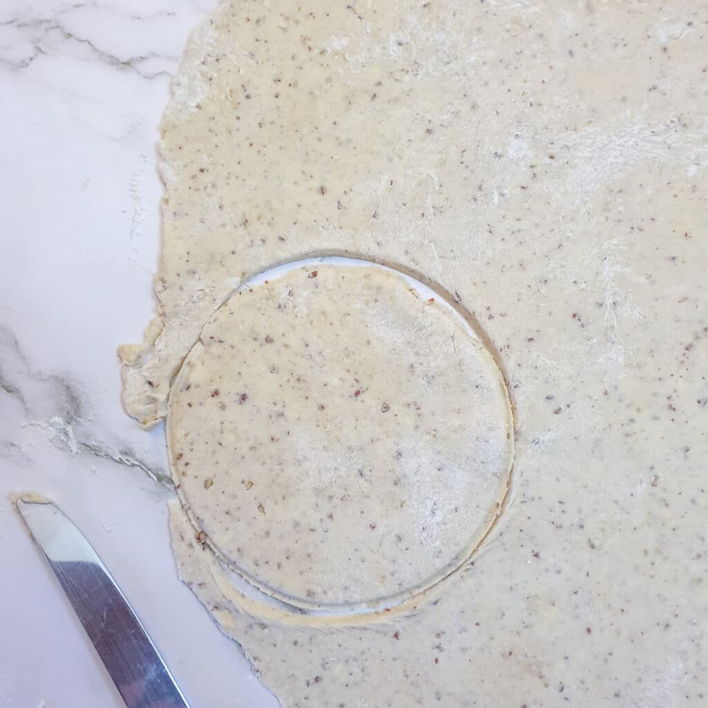 A circle of pastry ready to be placed in a baking dish.