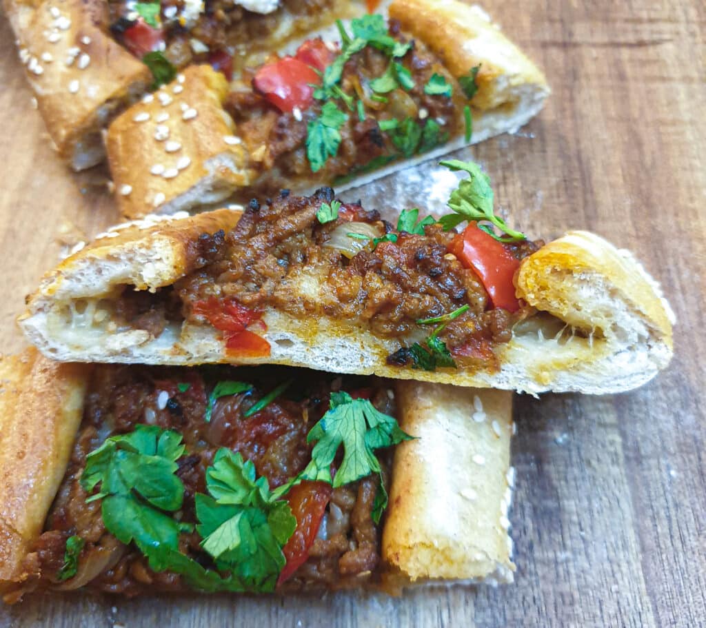 Side on view of a slice of lamb pide showing the texture of the bread.