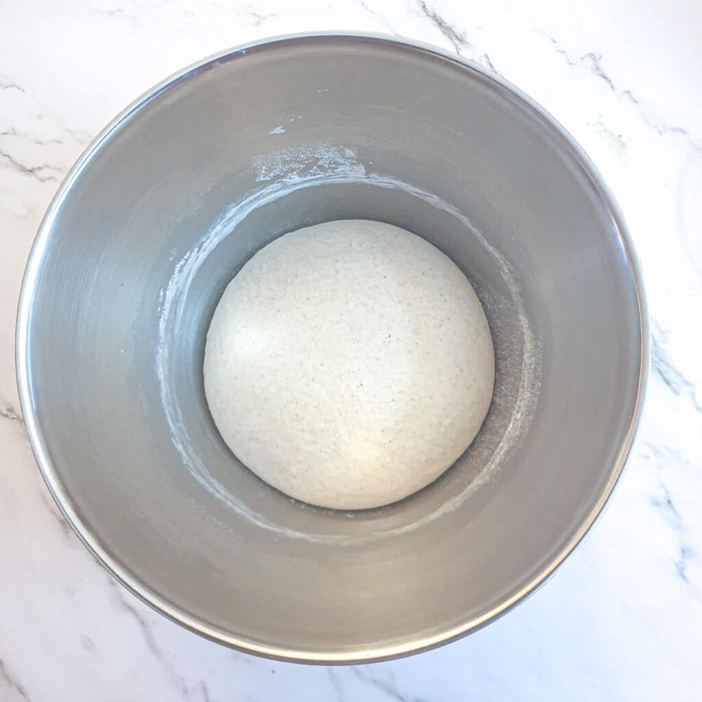 A ball of risen dough in a mixing bowl.