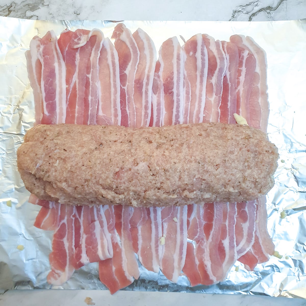 The chicken roll arrange on bacon rashers.