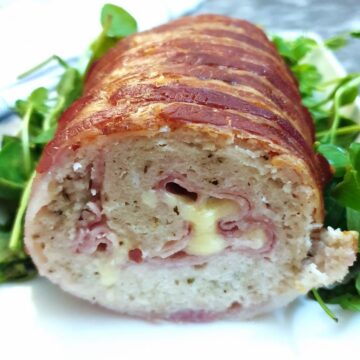 A cross-section view of a chicken and bacon meatloaf, showing the ham and cheese inside.