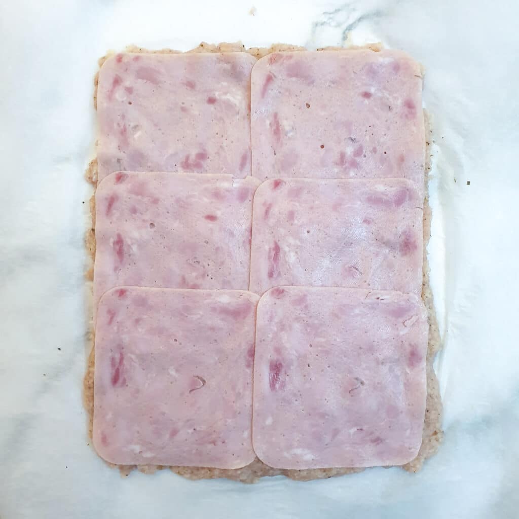 Minced chicken covered with slices of ham.
