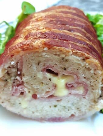 A cross-section view of a chicken and bacon meatloaf, showing the ham and cheese inside.