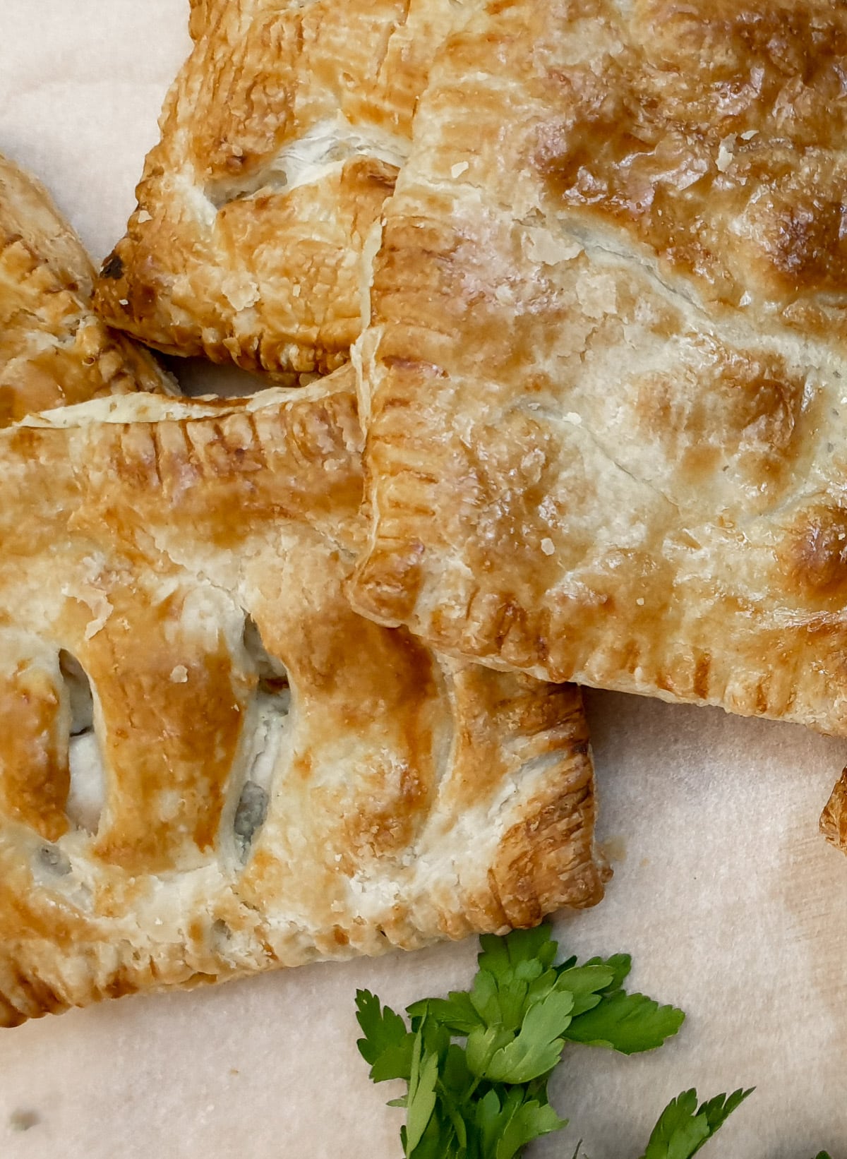 Closeup of 3 chicken and mushroom bakes showing the golden brown puff pastry.