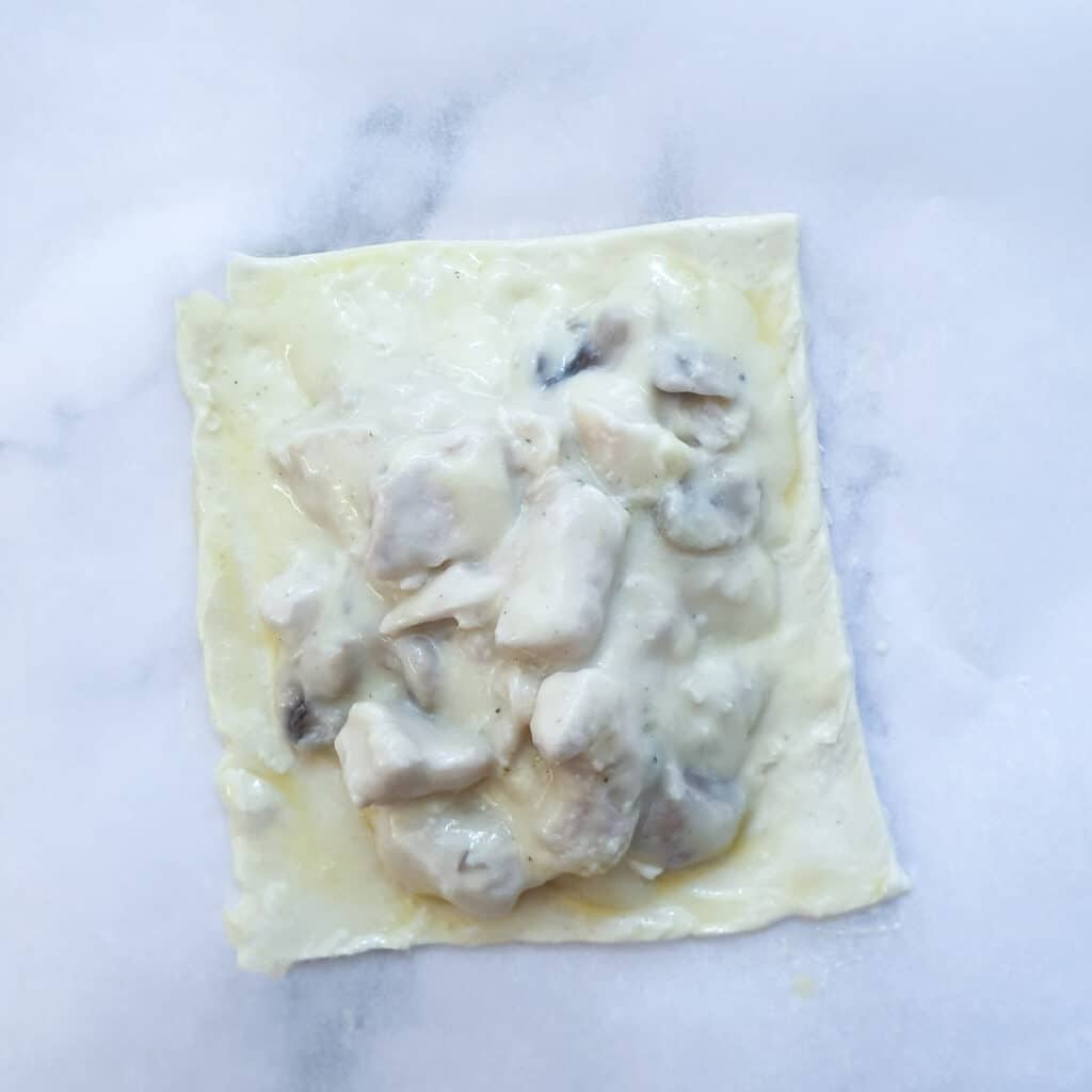 Chicken and mushroom filling on a rectangle of puff pastry.