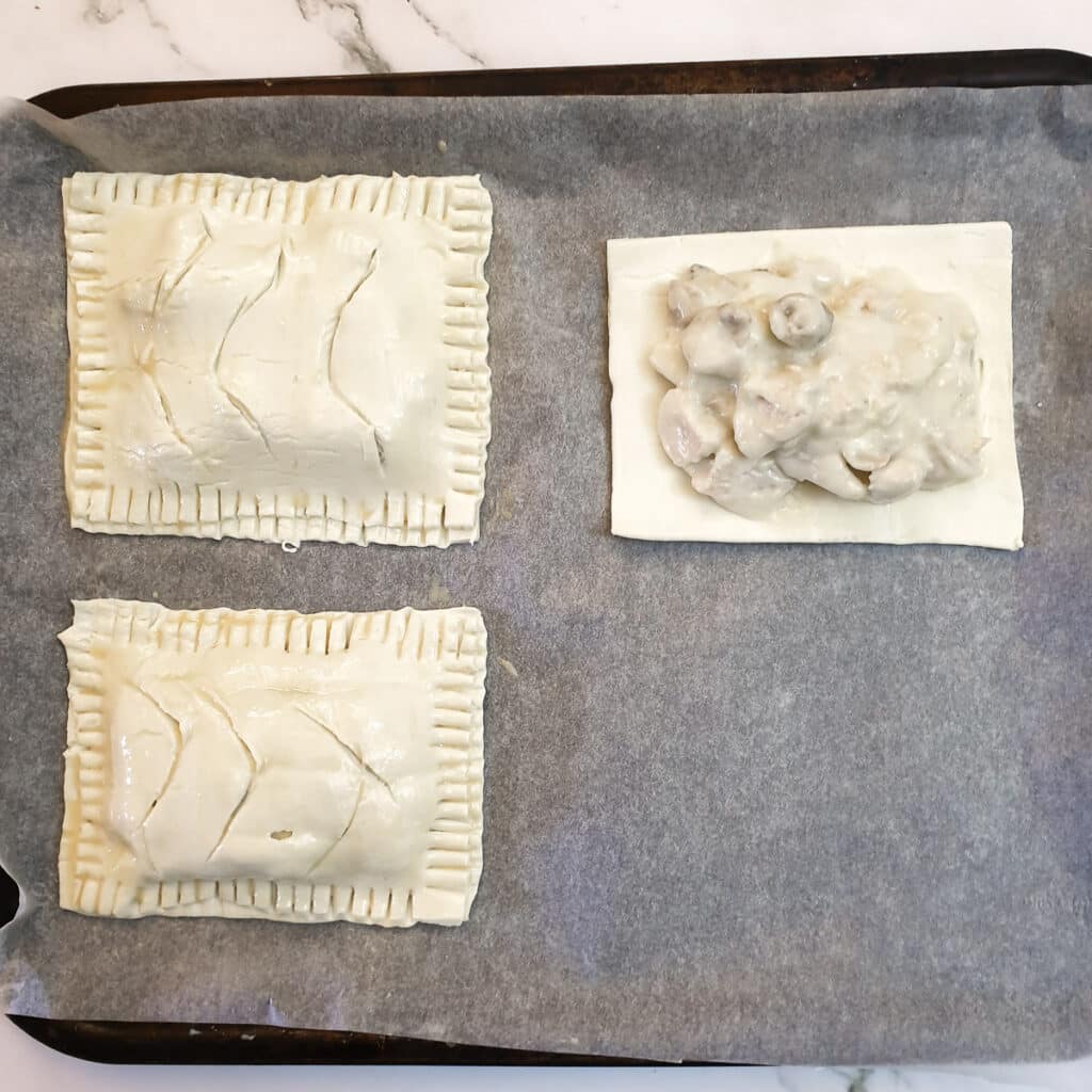 Chicken and mushroom bake being assembled on a baking sheet.