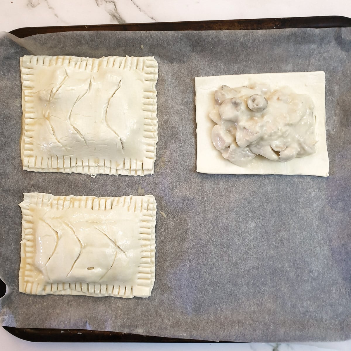 Chicken and mushroom bake being assembled on a baking sheet.