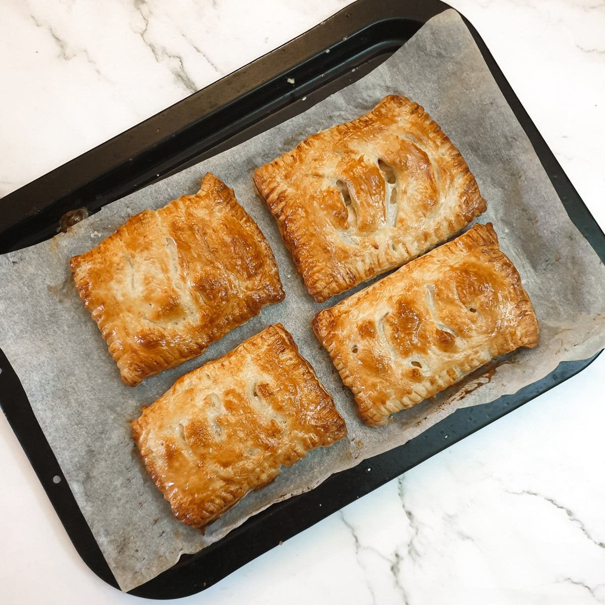 4 baked chicken and mushroom bakes on a baking sheet.