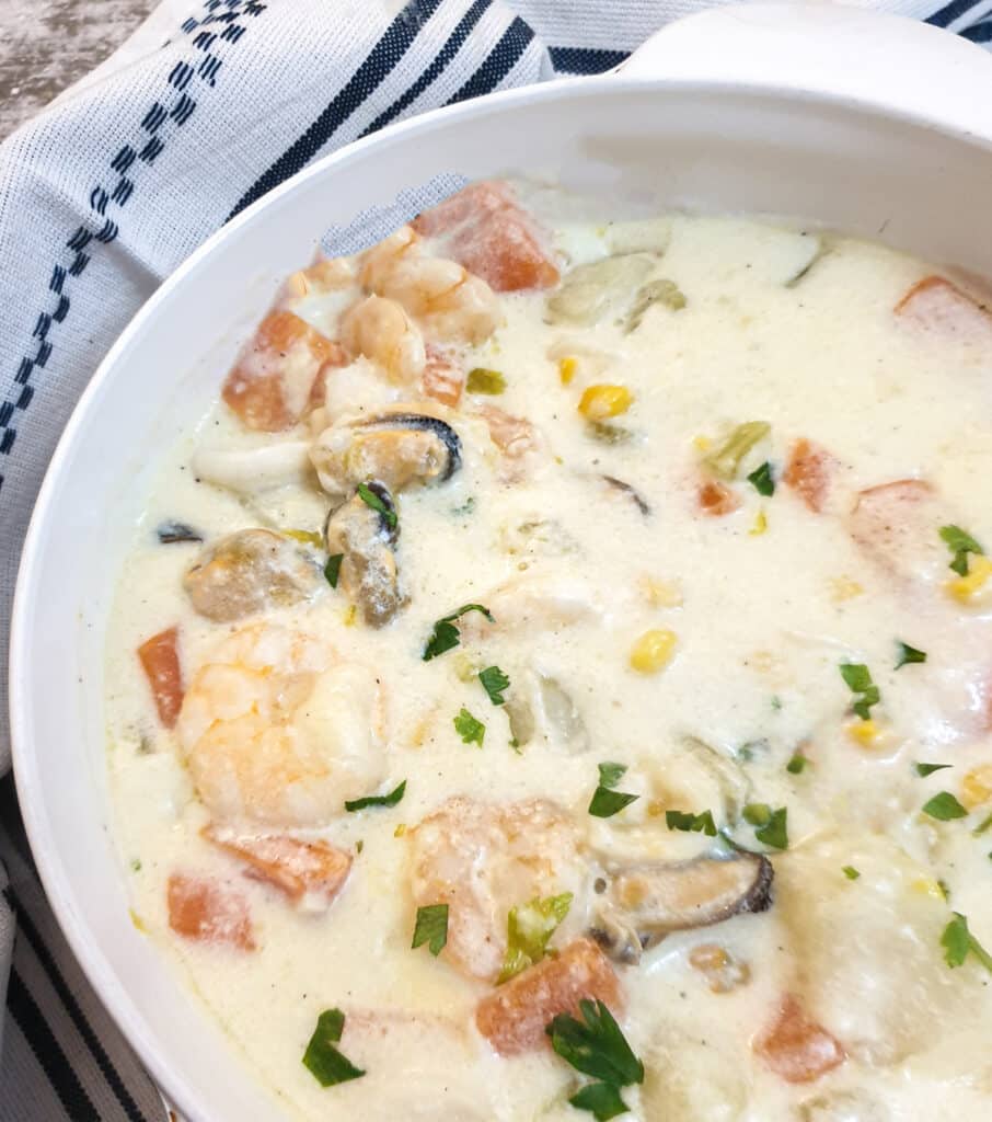 Close up of a bowl of Irish seafood chowder showing the amount  seafood and vegetables it contains.