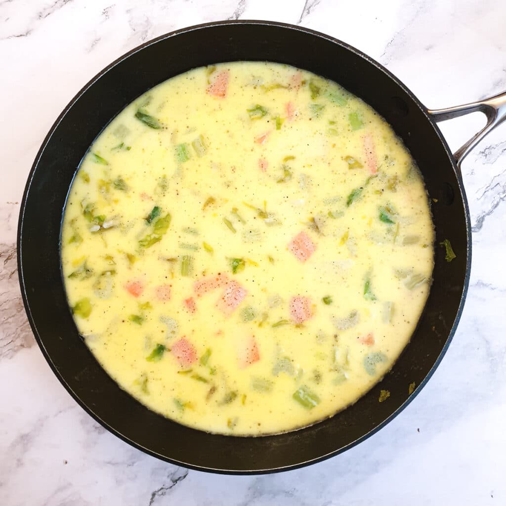 Milk, potatoes, carrots and celery in a large pan.