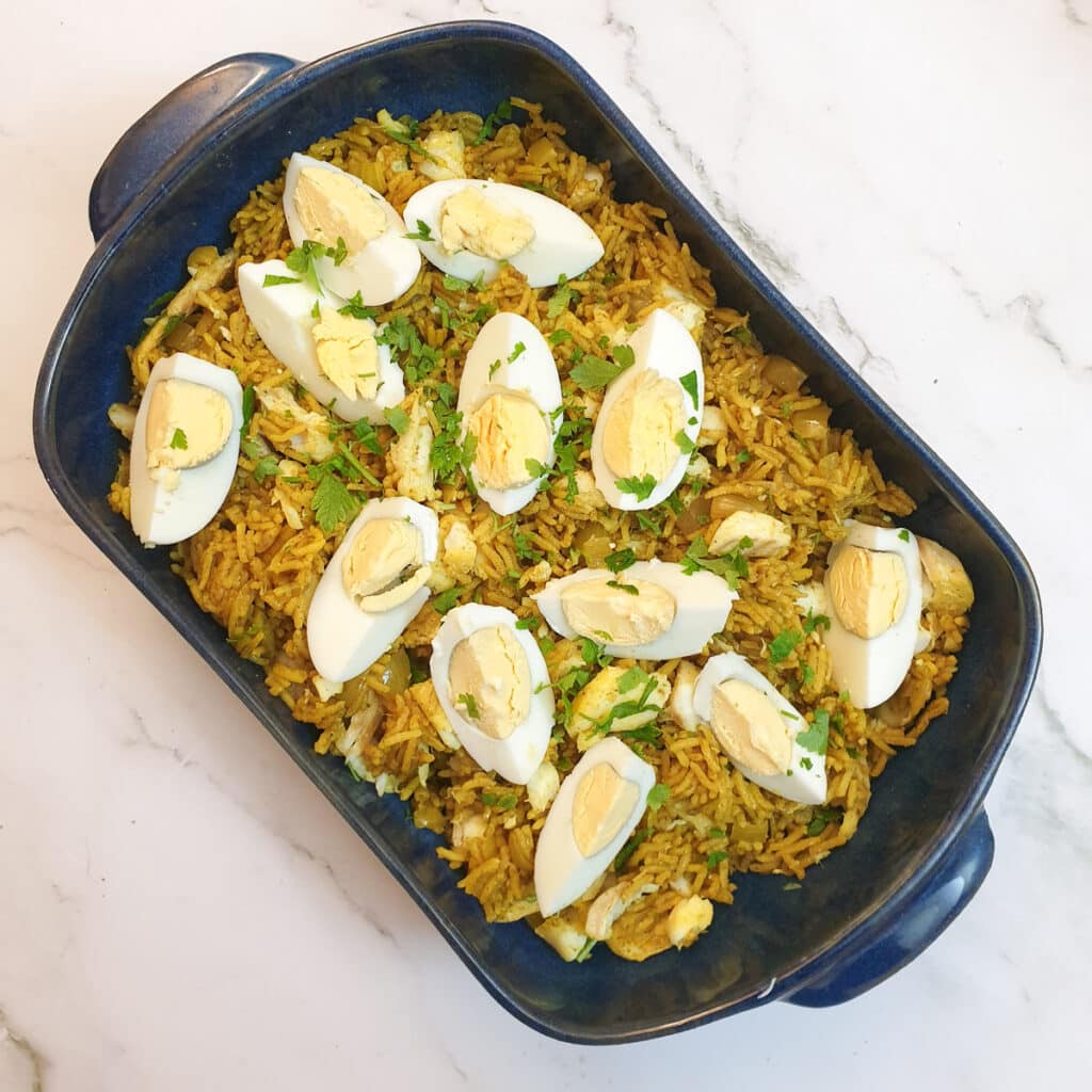 Overhead shot of smoked haddock kedgeree in a blue serving dish.