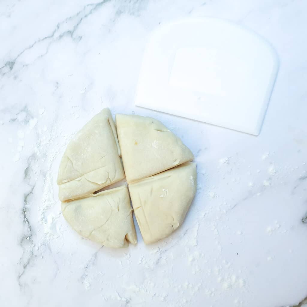 A ball of dough cut into 4 equal pieces.