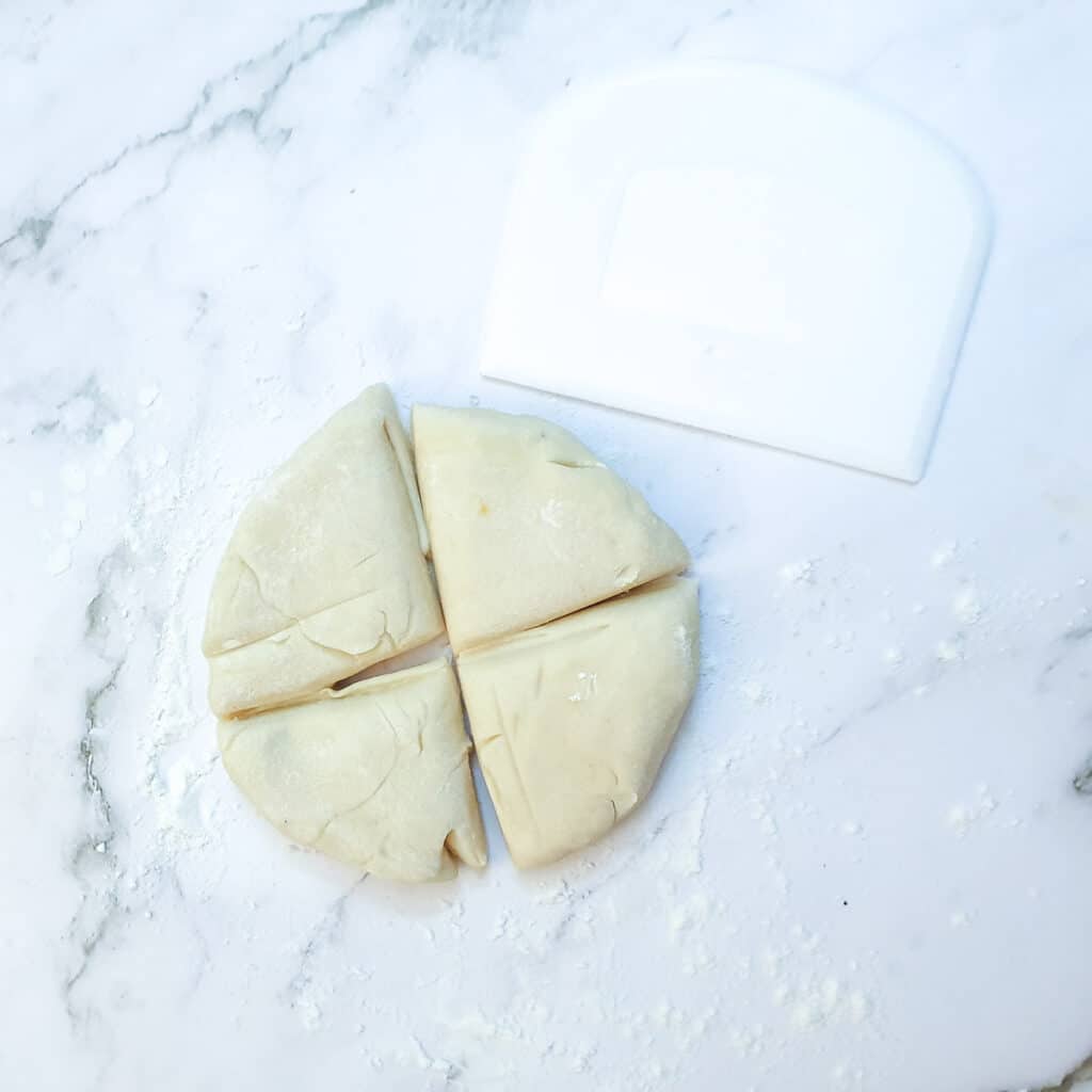 A ball of dough cut into 4 equal pieces.