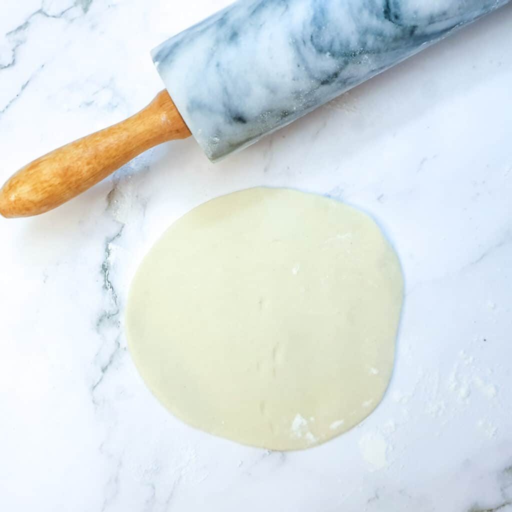 A circle of dough after being rolled with a rolling pin.