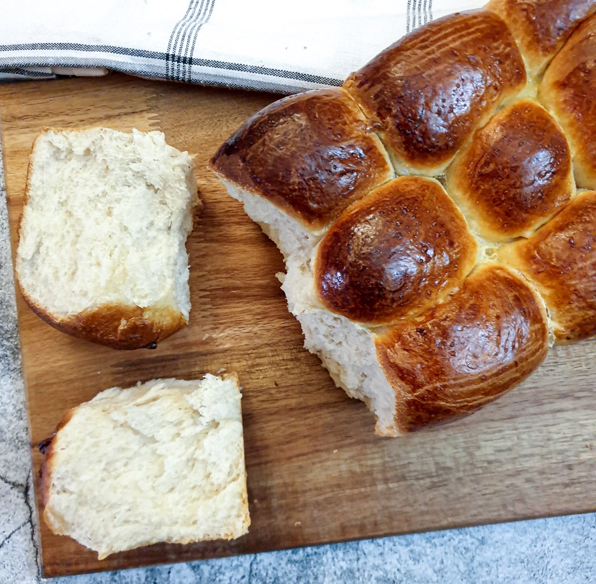 Overhead shot of two pieces of soft rusk which have been broken from the loaf.