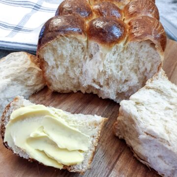 Close up of a soft condensed milk rusk (or mosbolletjie) spread with butter.