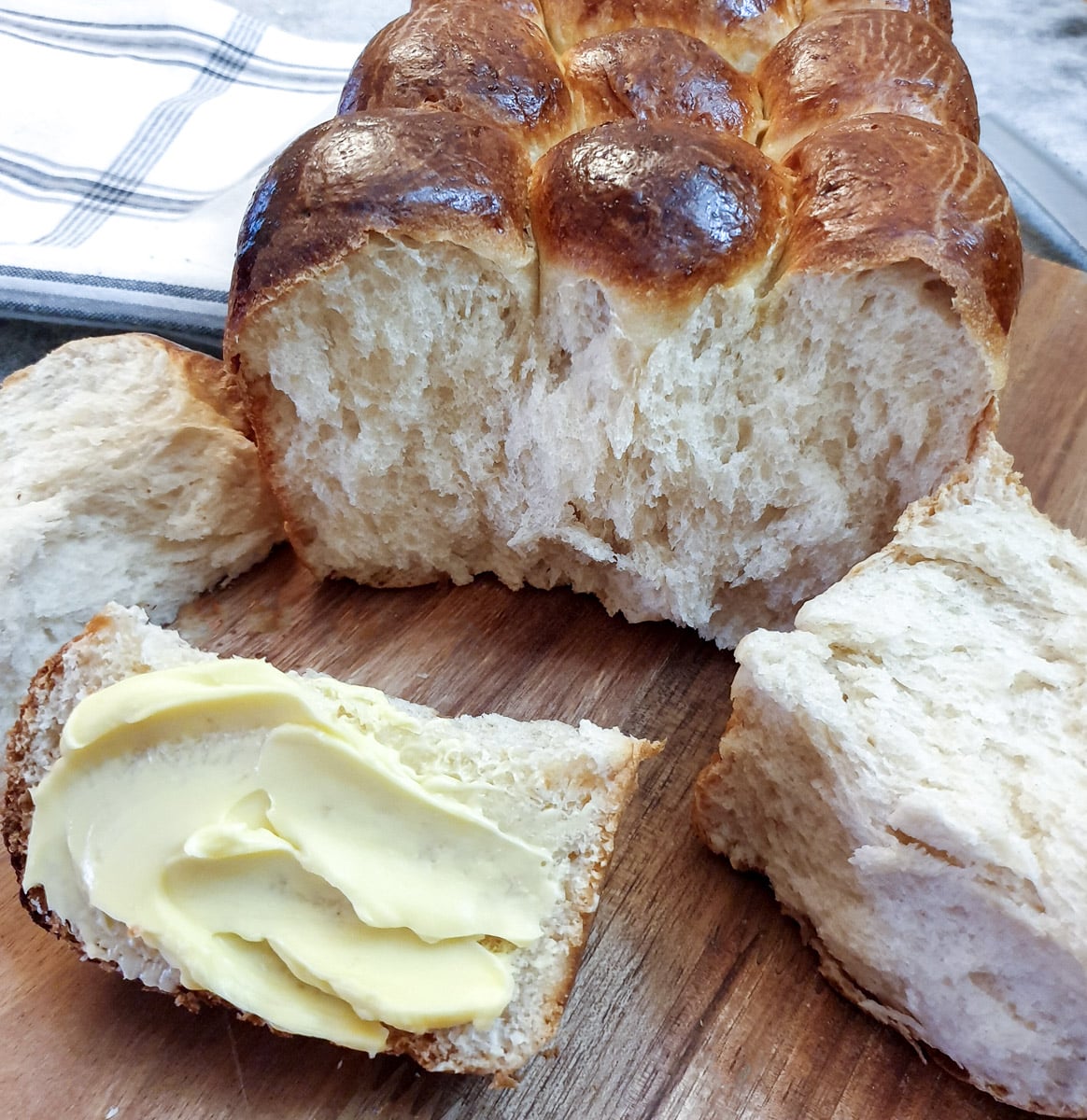 Close up of a soft condensed milk rusk (or mosbolletjie) spread with butter.