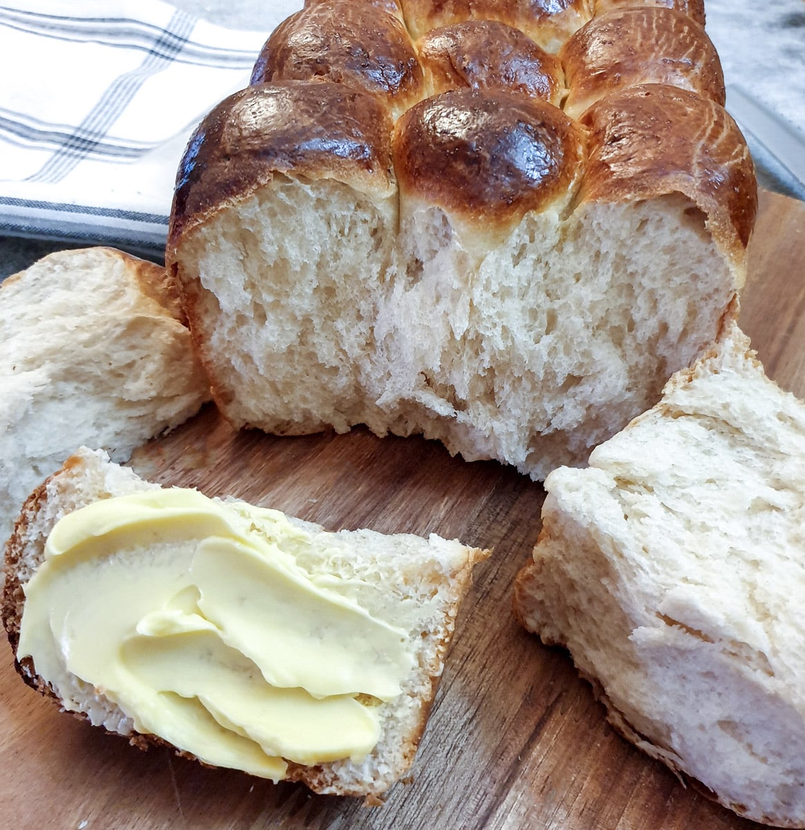 Close up of a soft condensed milk rusk (or mosbolletjie) spread with butter.