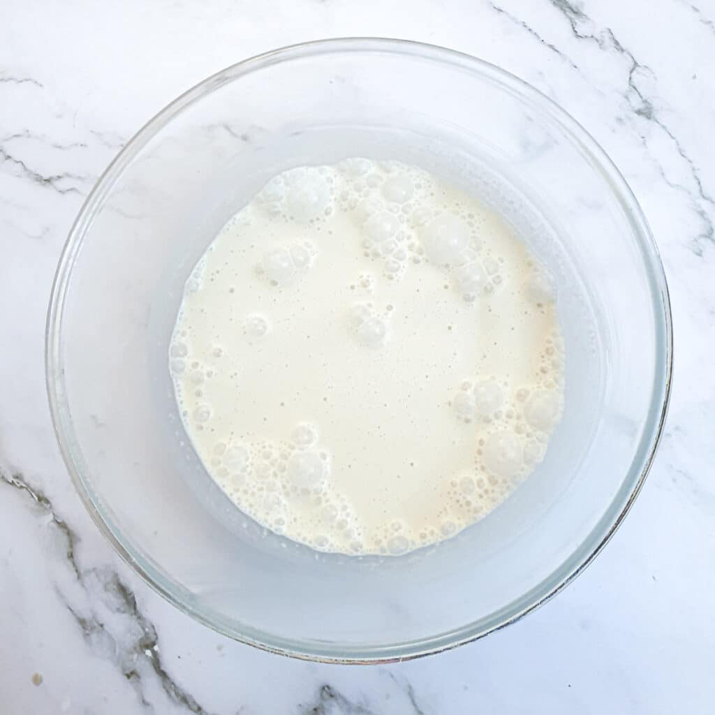 Evapourated milk being whisked in a mixing bowl.