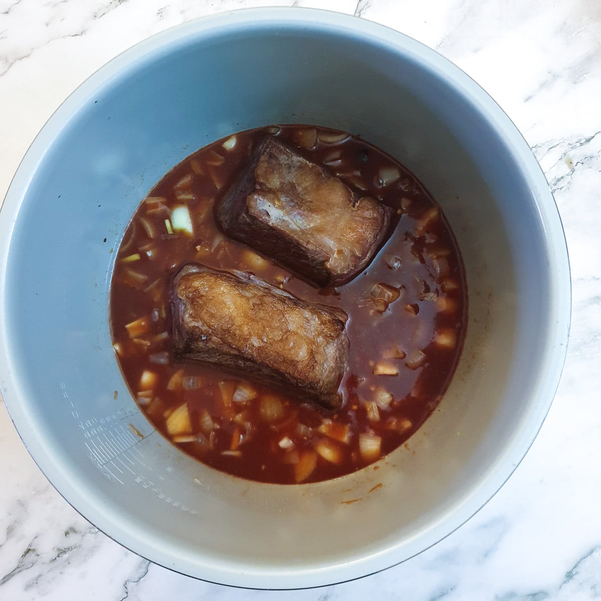 Monkey gland sauce ingredients in a Ninja multi-cooker with 2 large pieces of beef short rib.