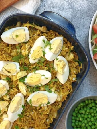 Smoked haddock kedgeree topped with hard-boiled eggs in a blue serving dish.