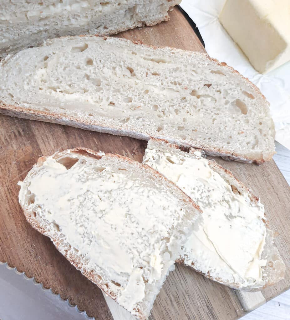 Two slices of chese and onion bread, one buttered and the other unbuttered to show the cheese and onion laminations.