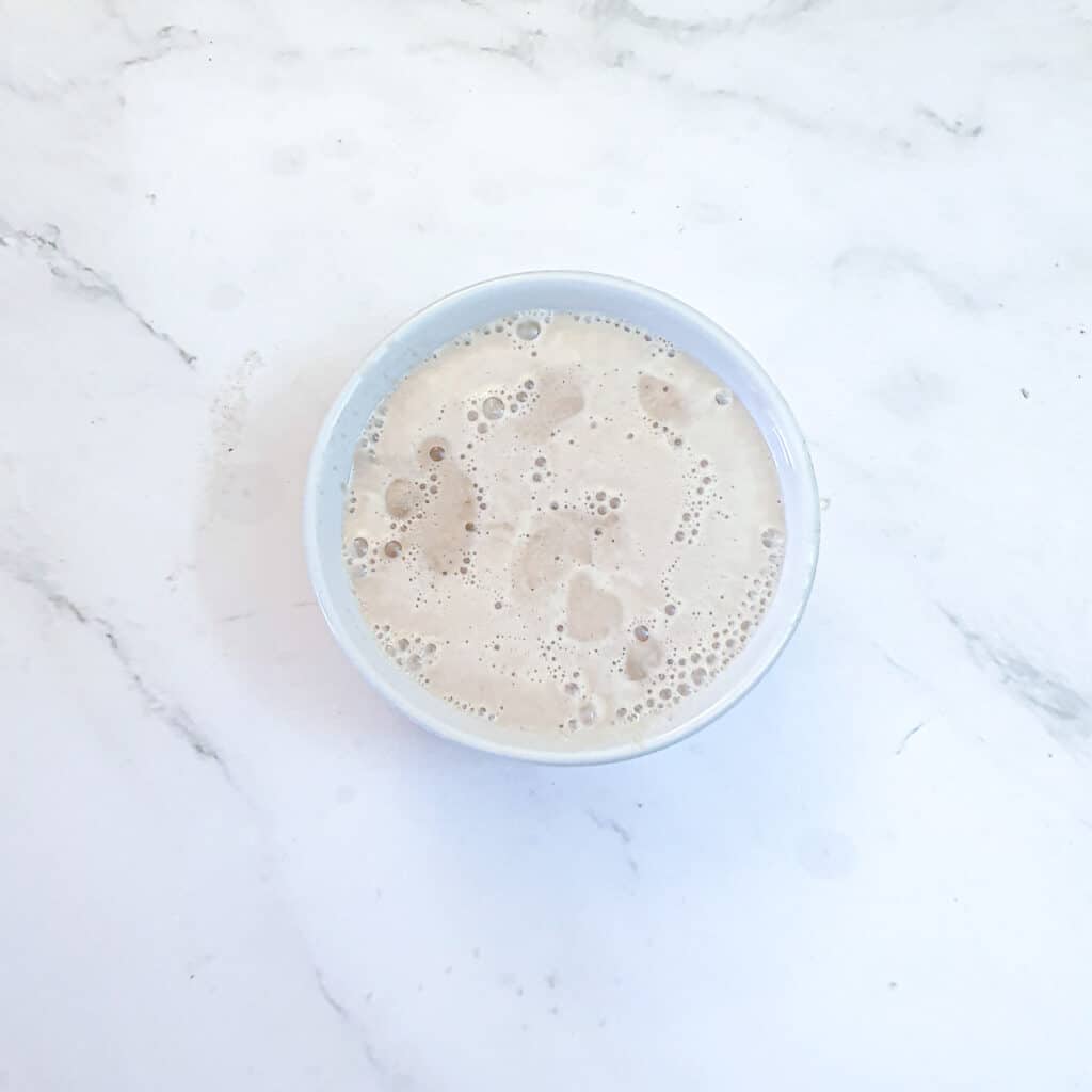 A bowl of yeast and water which has been left to stand for 5 minutes.