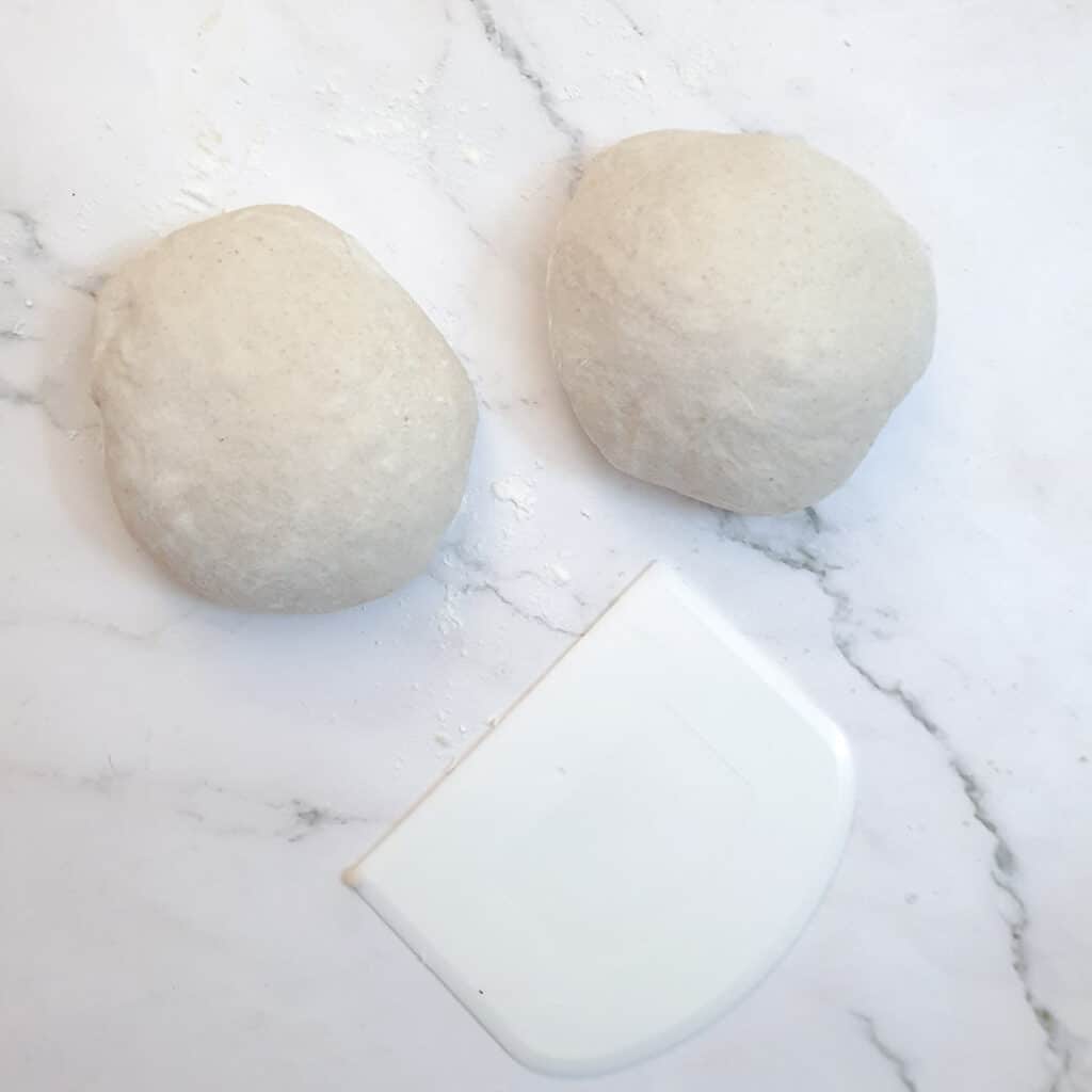 Dough for homemade pizzas divided into two balls.