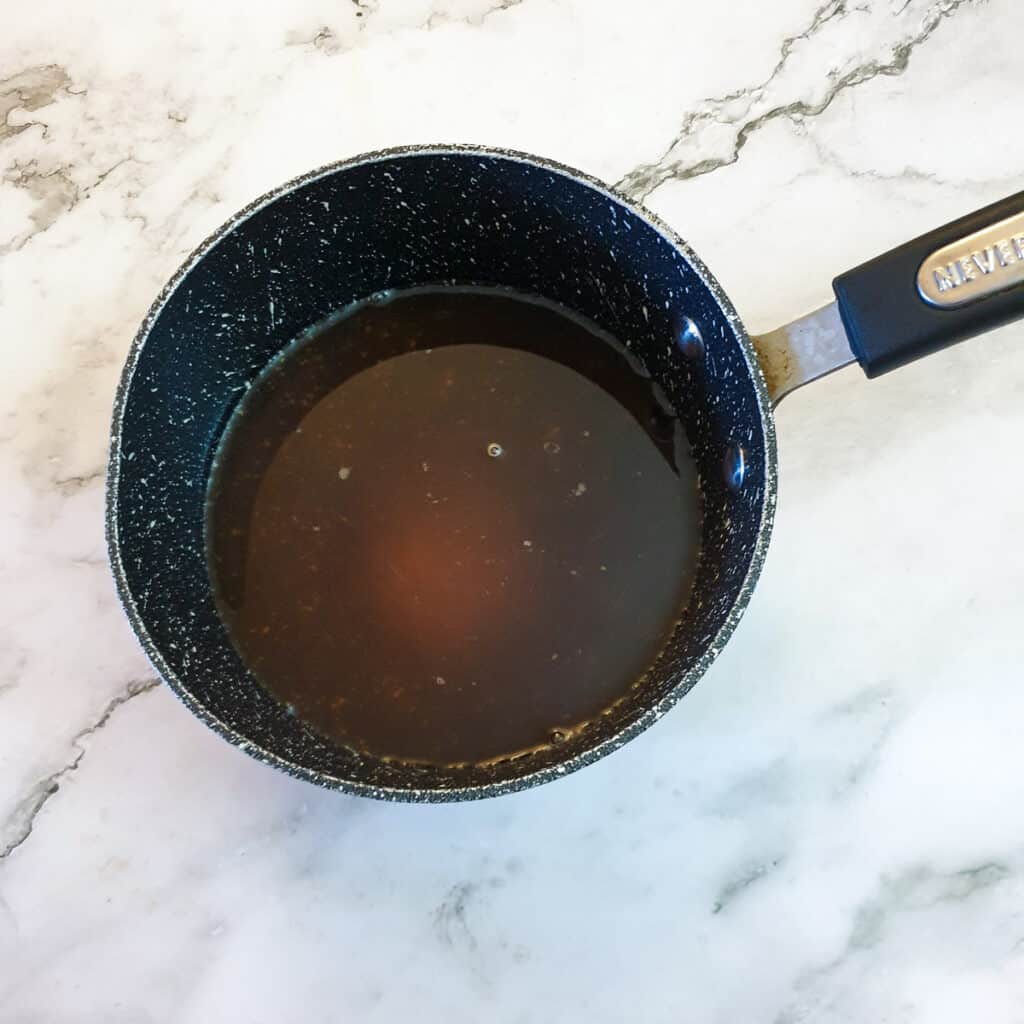 Vinegar, water, salt and sugar being brought to the boil in a small saucepan.