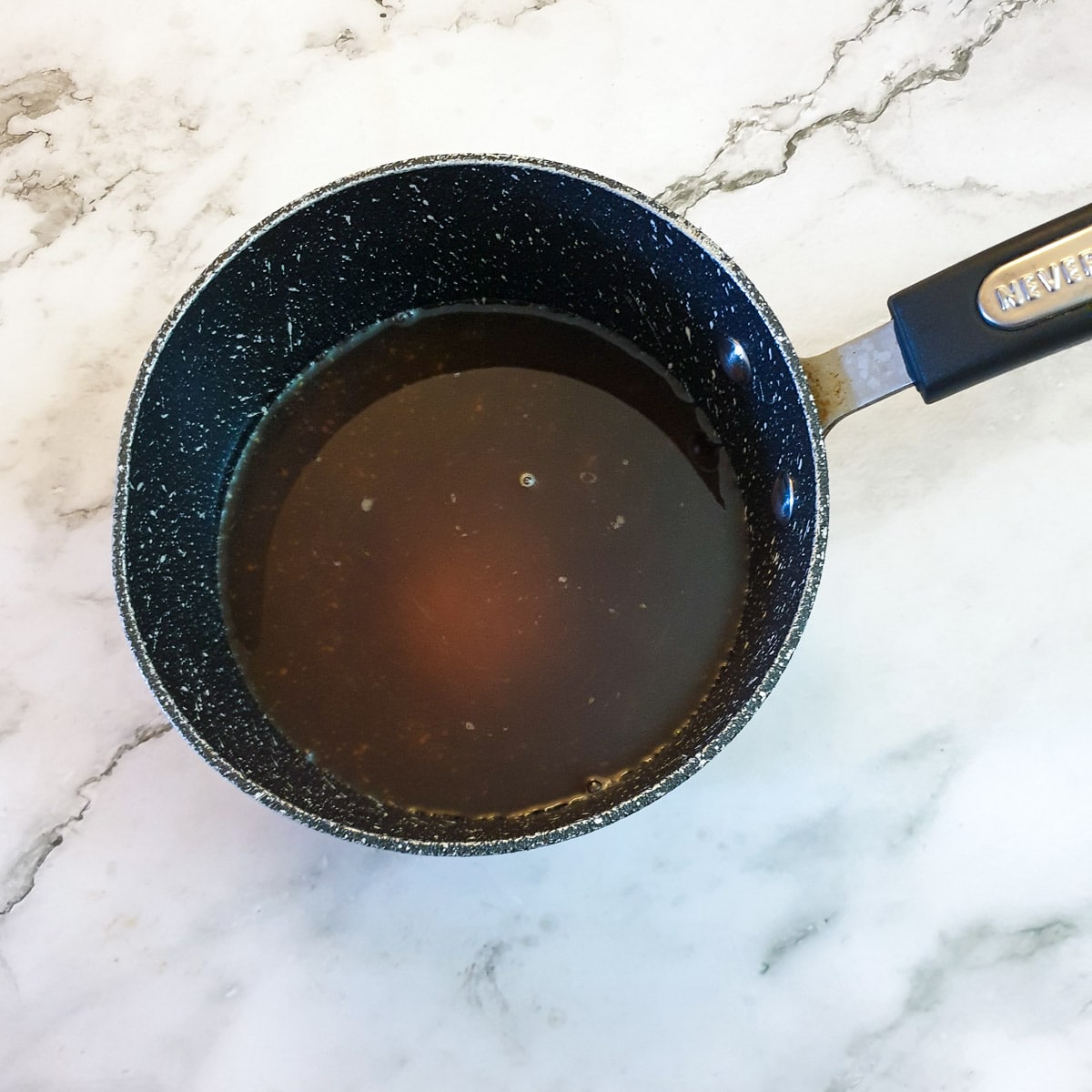 Vinegar, water, salt and sugar being brought to the boil in a small saucepan.