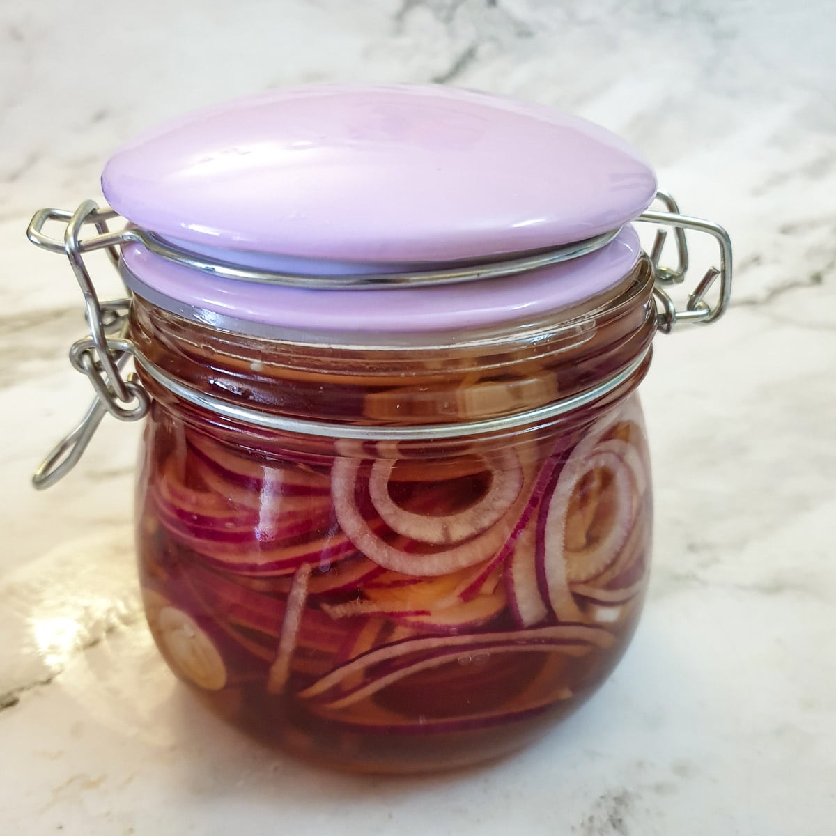 A sealed jar of pickled red onions.