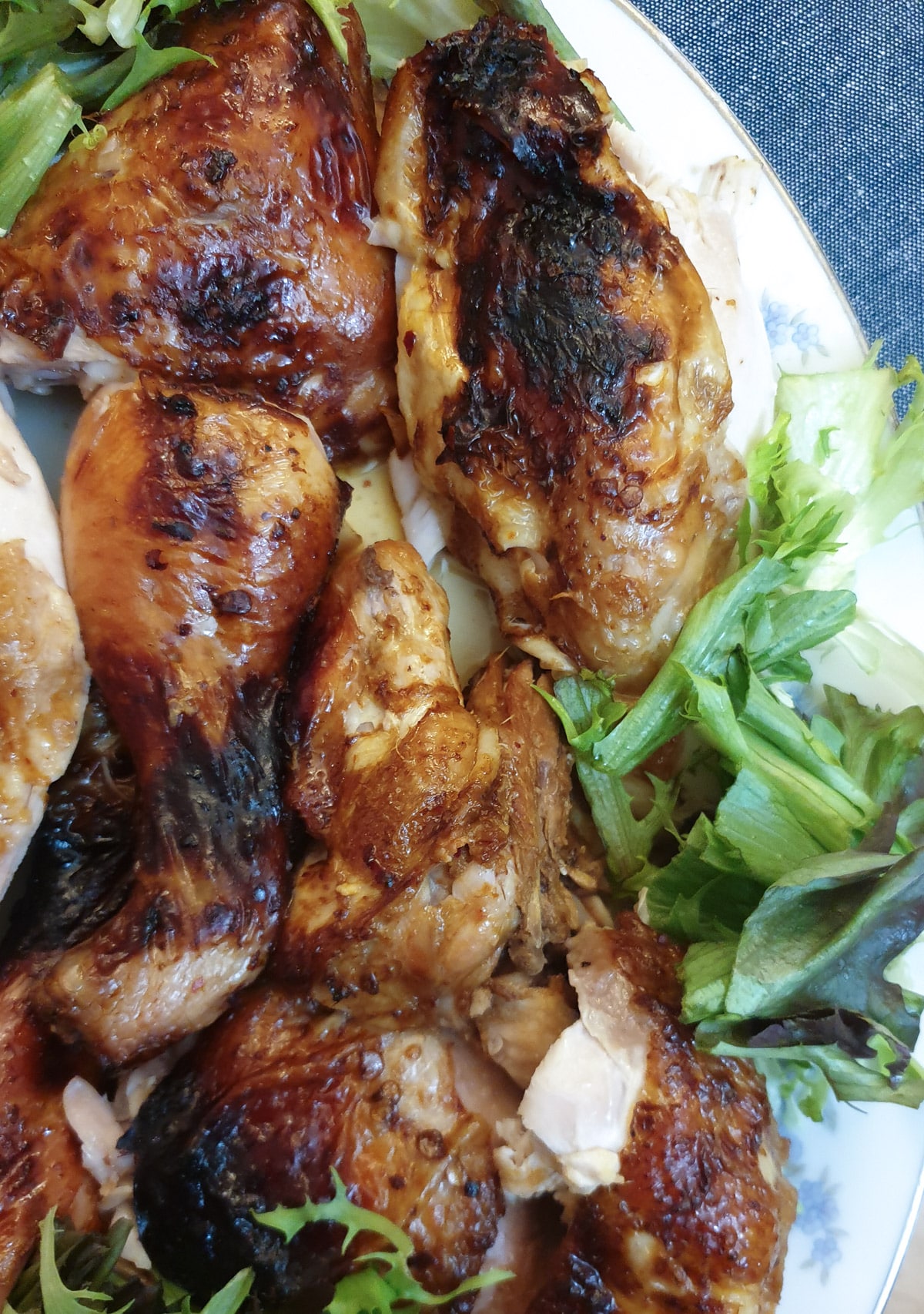 Closeup of pieces on chicken on a plate with lettuce.