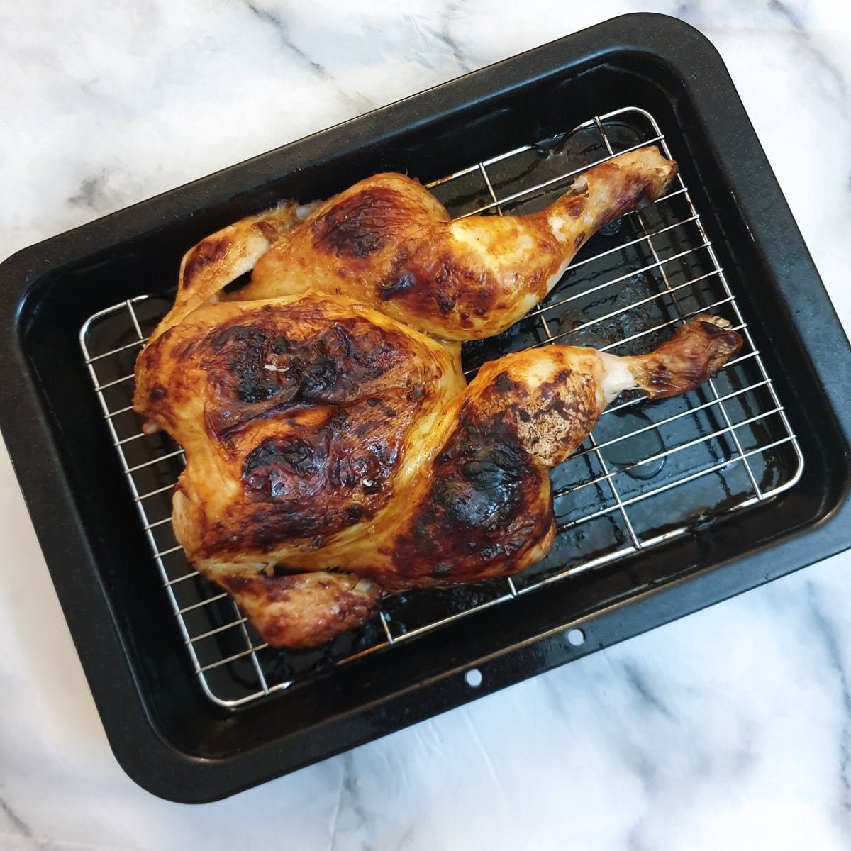 A whole roasted spatchcocked chicken in a peri peri marinade.