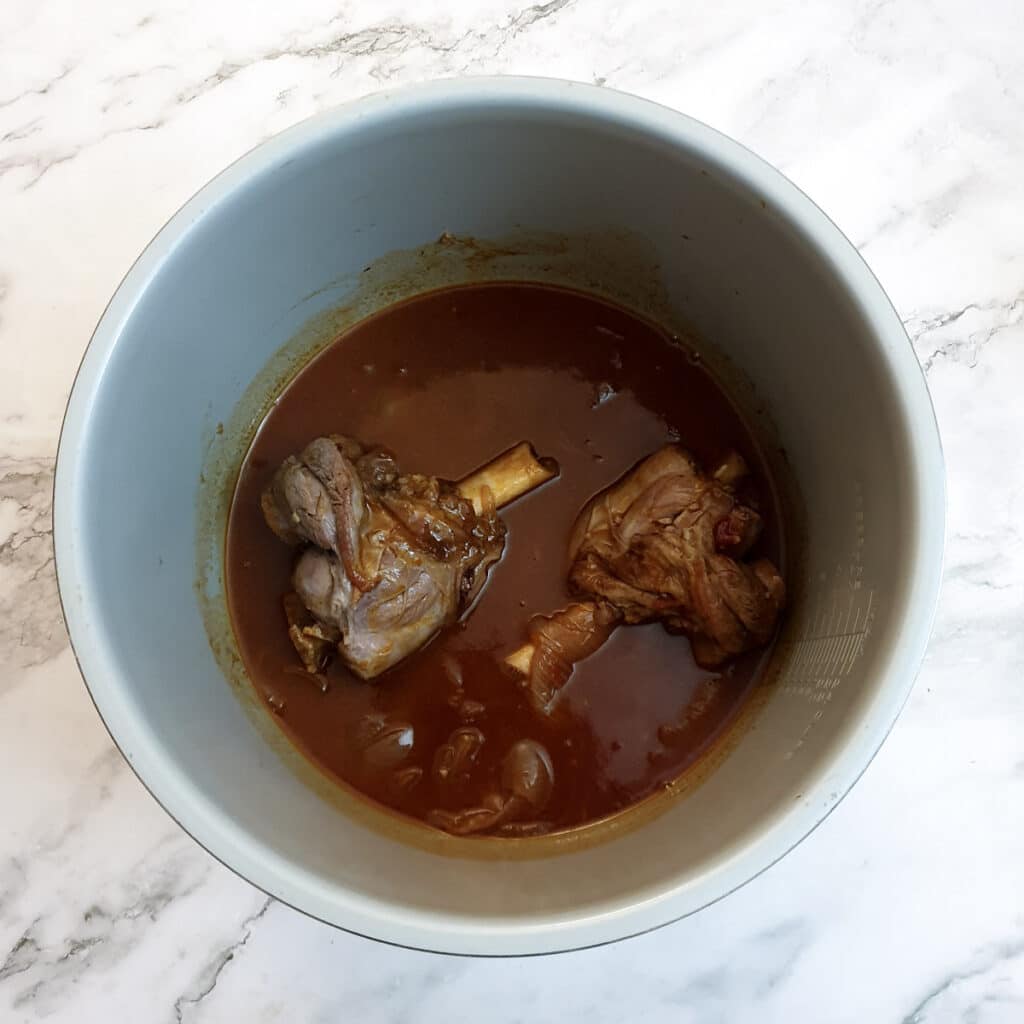 2 almost fully-cooked lamb shanks in a pressure cooker.