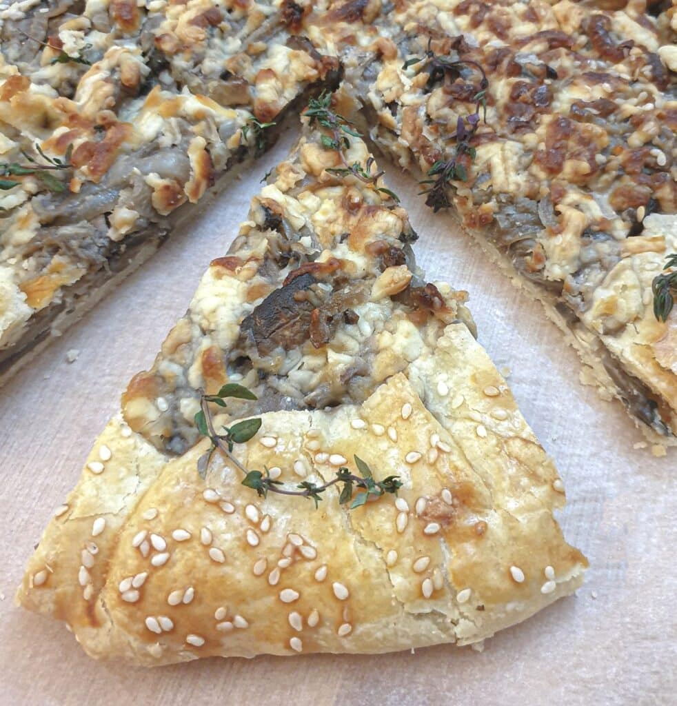 A slice of mushroom galette offset from the main pie.