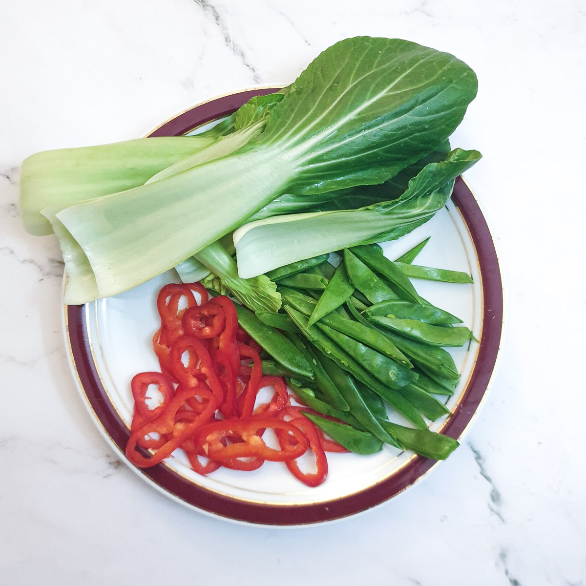 Chopped pak choi, sugar snaps and red pepper ready to be added to the Thai fish parcels.