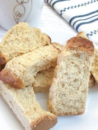 A pile of buttermilk rusks next to a striped blue and white cloth.