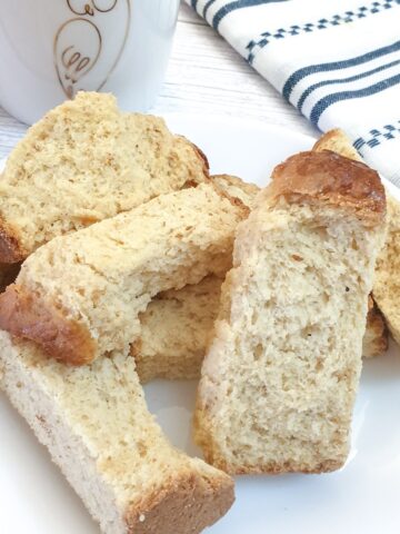 A pile of buttermilk rusks next to a striped blue and white cloth.