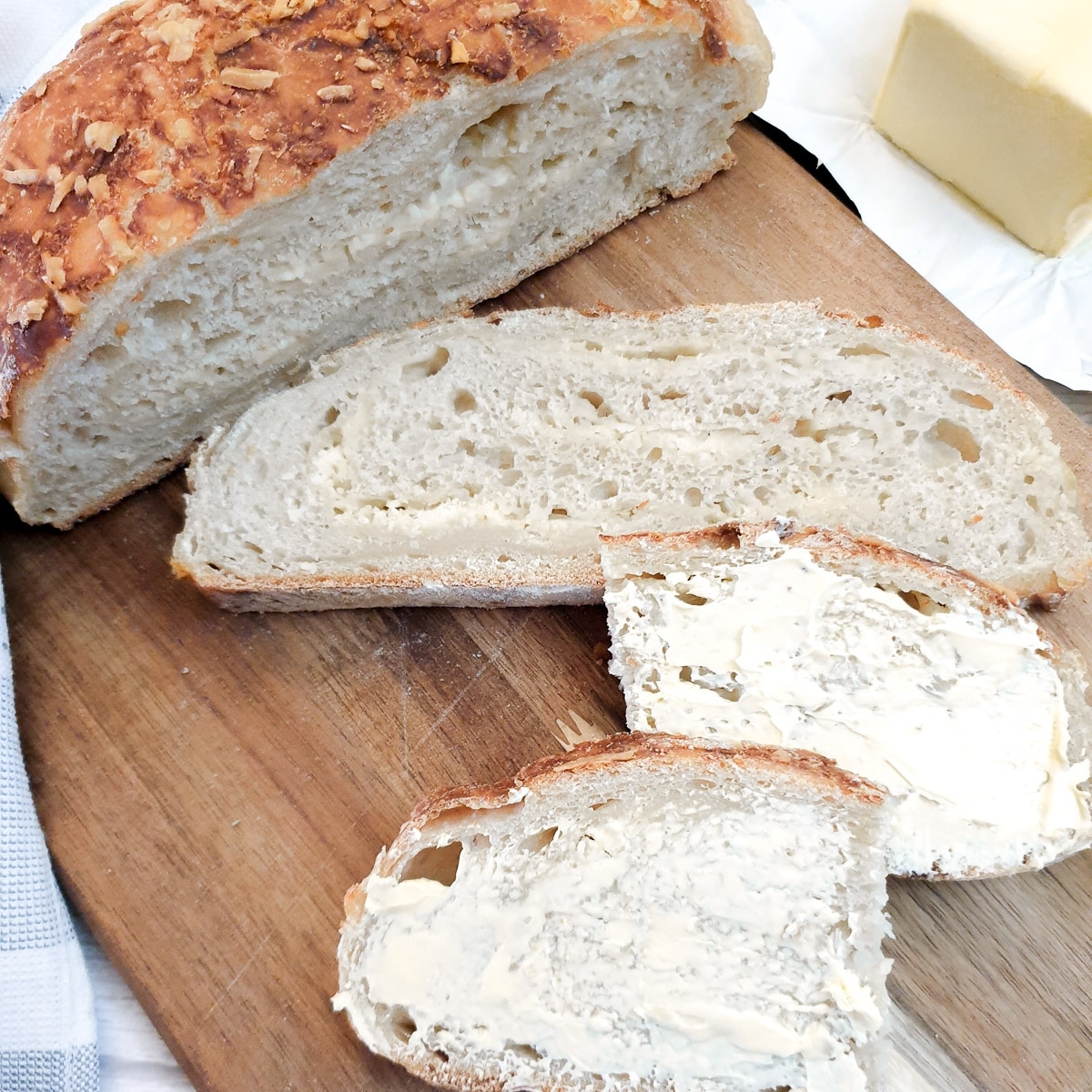 Two slices of chese and onion bread, one buttered and the other unbuttered to show the cheese and onion laminations.