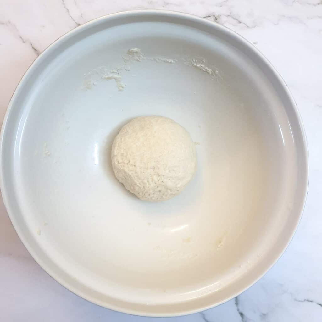 A ball of dough in a mixing bowl.